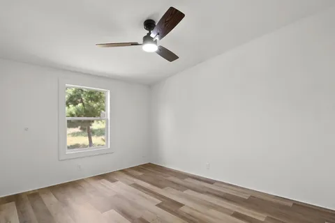 a view of a livingroom with wooden floor and a ceiling fan