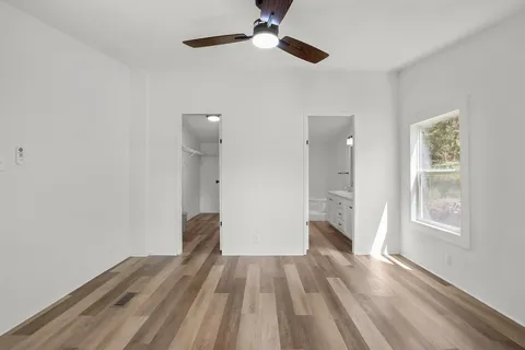 a view of a livingroom with wooden floor and a ceiling fan