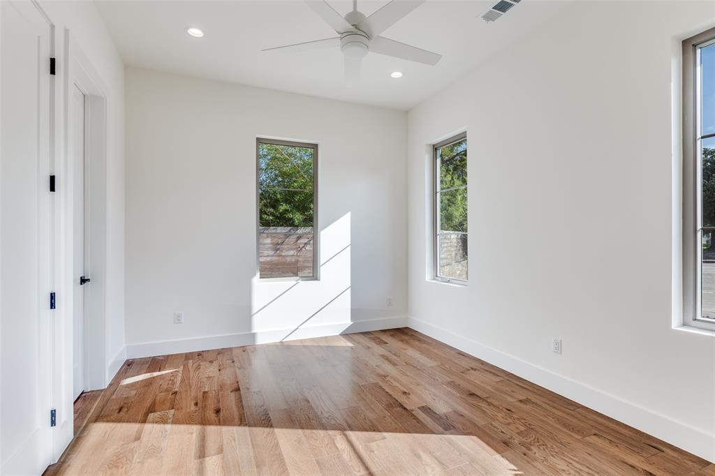 11131 Hillcrest Road Dallas, TX 75230 - Photo 16 of 24 an empty room with wooden floor cabinet and windows