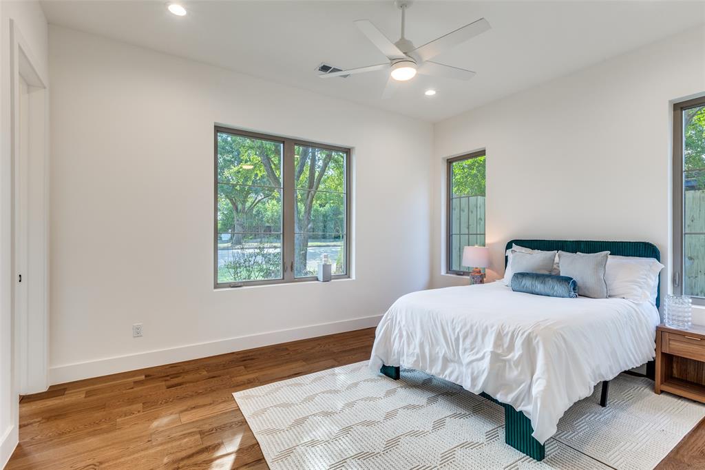 11131 Hillcrest Road Dallas, TX 75230 - Photo 18 of 24 a bedroom with a large bed and a ceiling fan