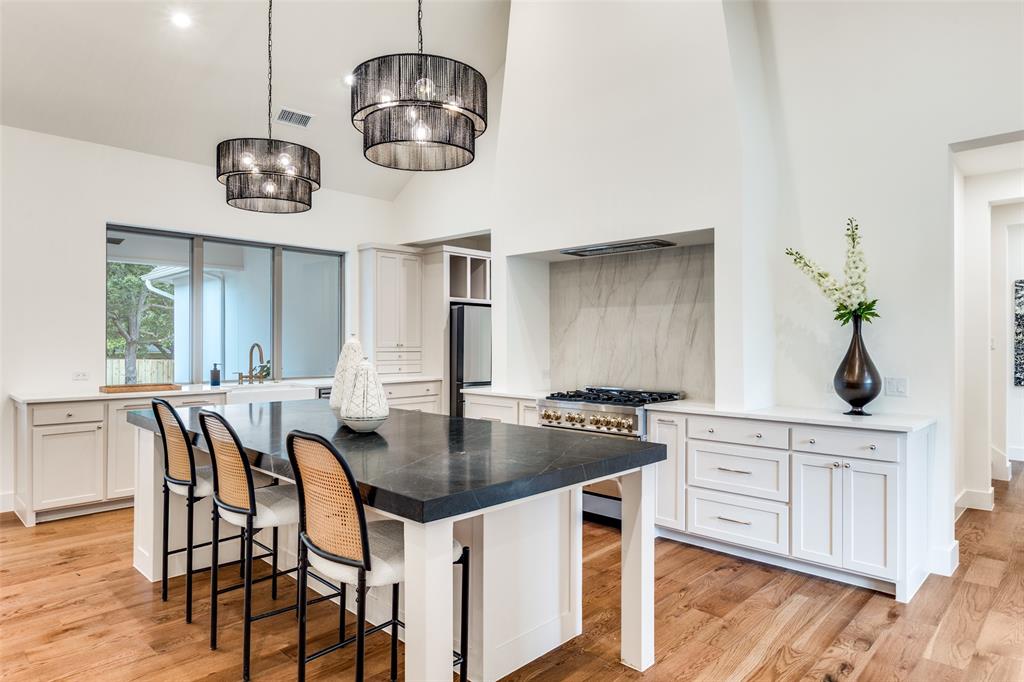 11131 Hillcrest Road Dallas, TX 75230 - Photo 7 of 24 a kitchen with stainless steel appliances a table chairs and cabinets