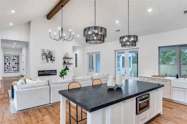 a kitchen with stainless steel appliances a counter space a sink and chandelier