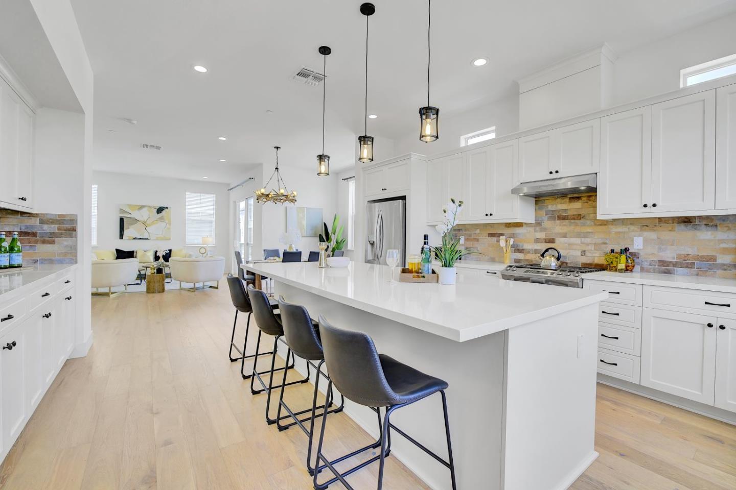37356 Suncrest Street Newark, CA 94560 - Photo 15 of 47 a kitchen with stainless steel appliances kitchen island granite countertop a table chairs and a refrigerator