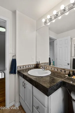 a bathroom with a granite countertop sink and a mirror