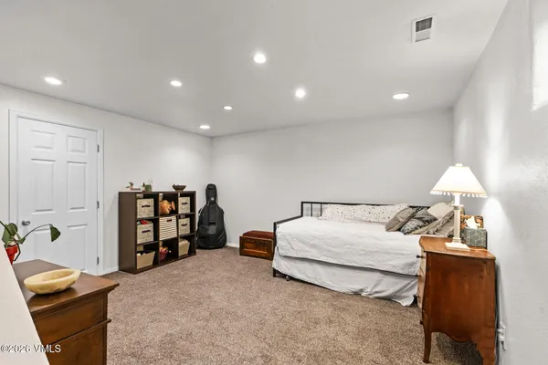 a spacious bedroom with a bed and a book shelf