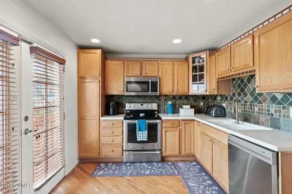 a kitchen with stainless steel appliances granite countertop a refrigerator sink and stove