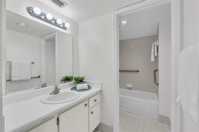 a bathroom with a sink double vanity granite tub and shower