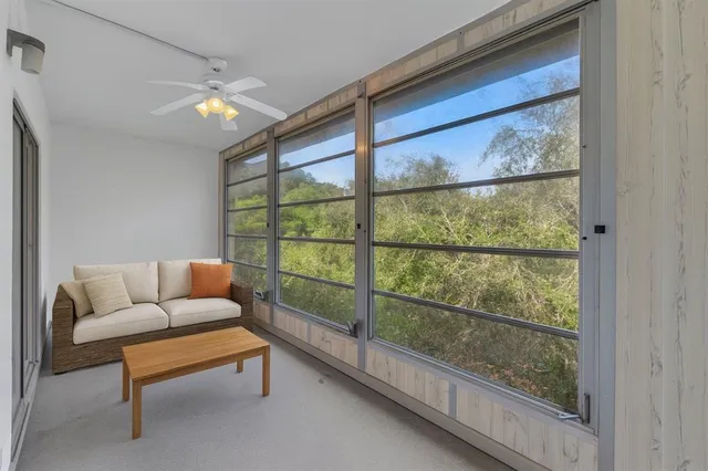 a living room with white walls and a large window