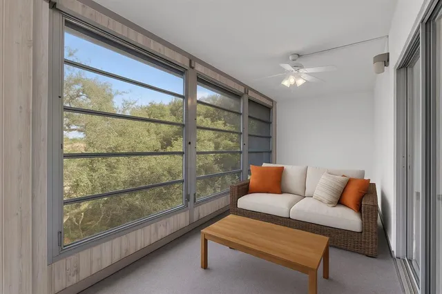 a blue couch sitting in a living room next to a window