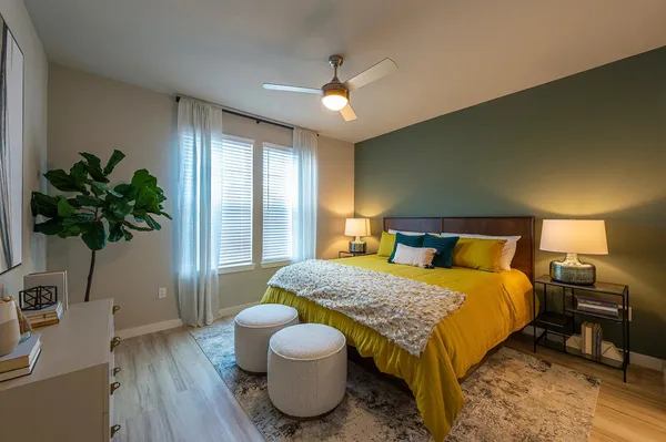 a spacious bedroom with a bed and a potted plant