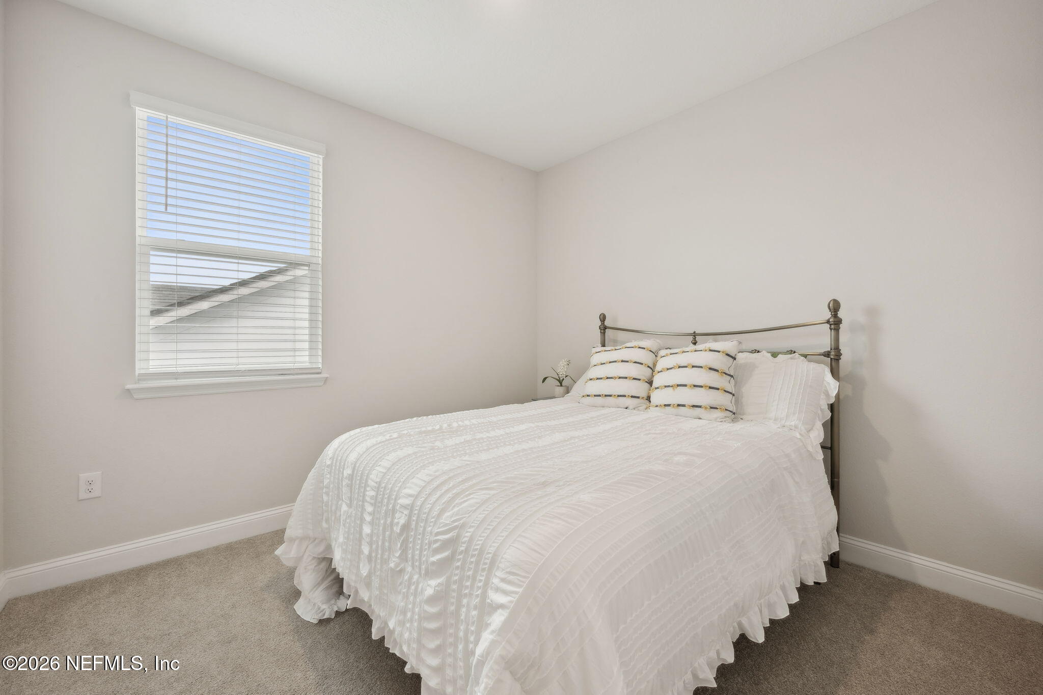 141 Redbud Lane Yulee, FL 32097 - Photo 35 of 77 a large bed sitting in a bedroom next to a window