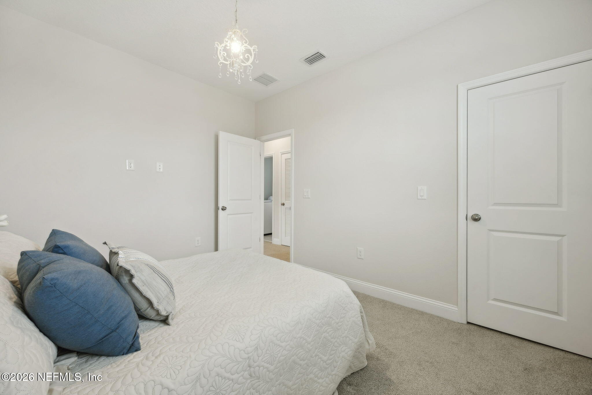 141 Redbud Lane Yulee, FL 32097 - Photo 41 of 77 a bedroom with a bed and a chandelier