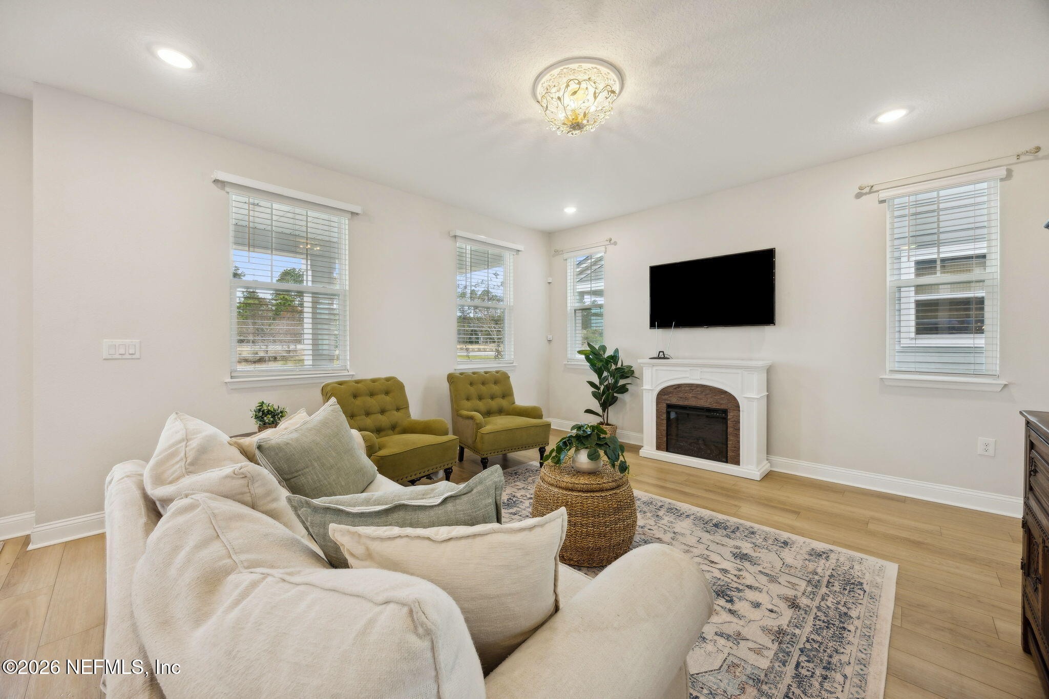 141 Redbud Lane Yulee, FL 32097 - Photo 10 of 77 a living room with furniture a fireplace and a flat screen tv