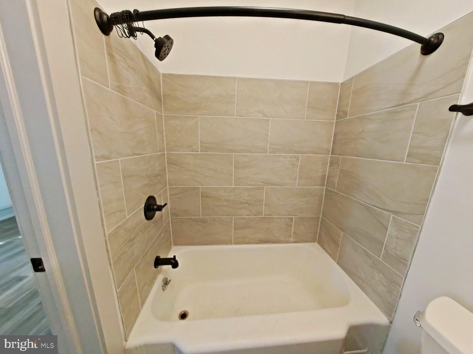 5606 Ridge Avenue, Unit 3F Philadelphia, PA 19128 - Photo 3 of 10 a bathroom with a bathtub