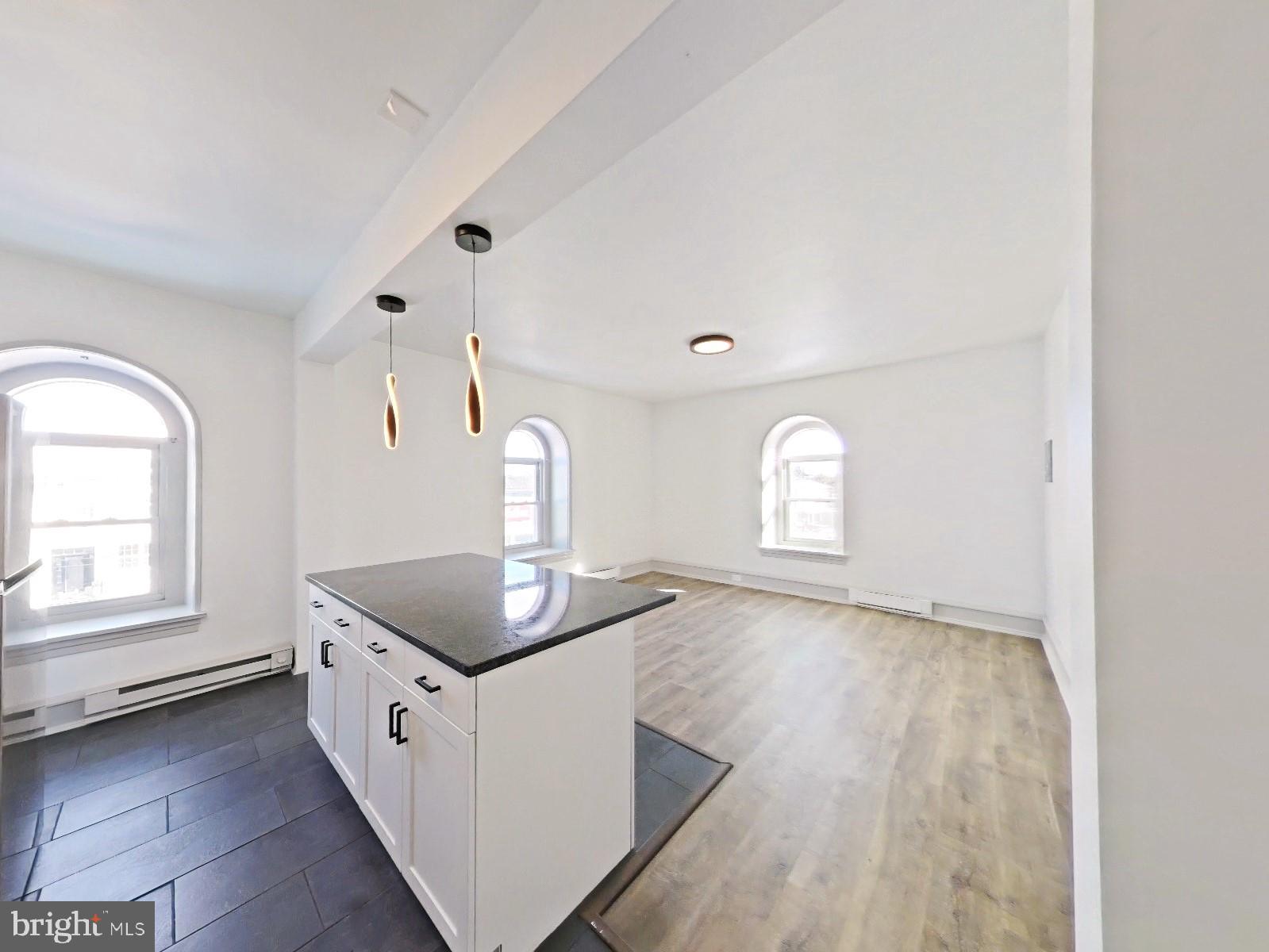 5606 Ridge Avenue, Unit 3F Philadelphia, PA 19128 - Photo 6 of 10 a kitchen with granite countertop white cabinets and window