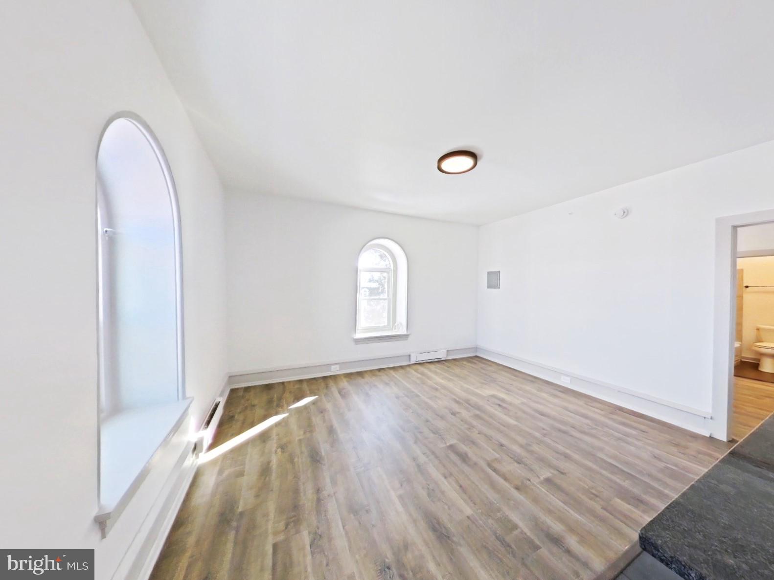 5606 Ridge Avenue, Unit 3F Philadelphia, PA 19128 - Photo 8 of 10 an empty room with wooden floor and window