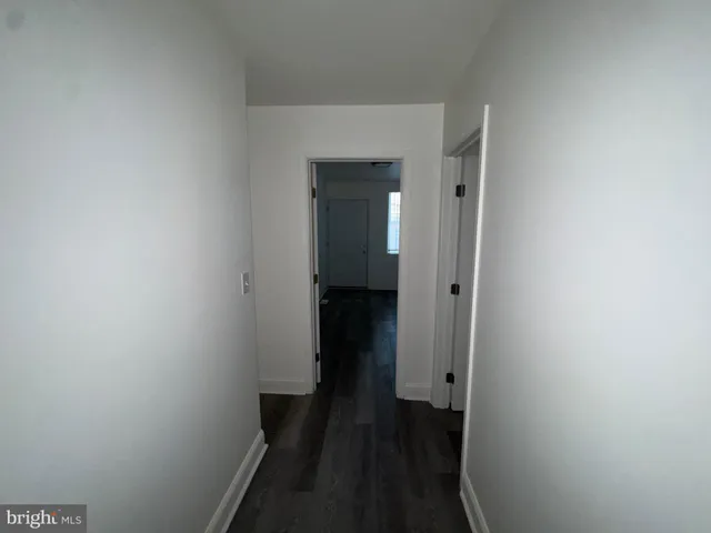 a view of a hallway with wooden floor and closet