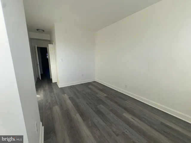 a view of a room with wooden floor and white walls