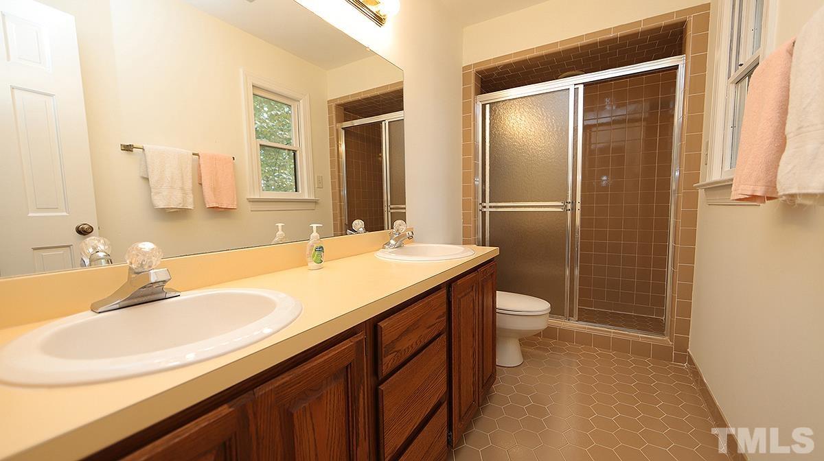 8700 Mourning Dove Road Raleigh, NC 27615 - Photo 21 of 30 a bathroom with a double vanity sink toilet and shower