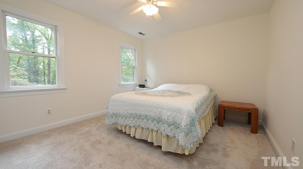 8700 Mourning Dove Road Raleigh, NC 27615 - Photo 22 of 30 a bedroom with a bed and a chandelier