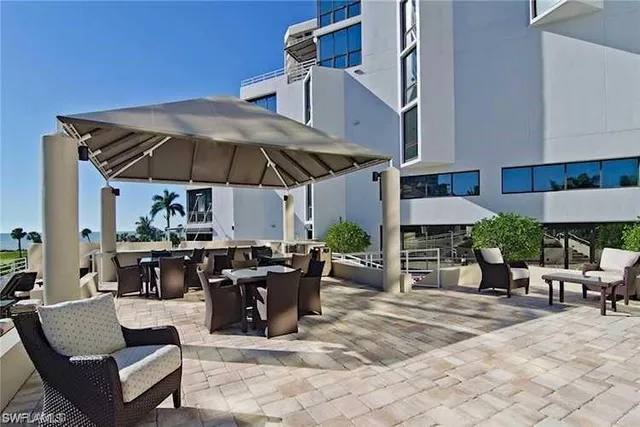 a view of a patio with a dining table and chairs under an umbrella