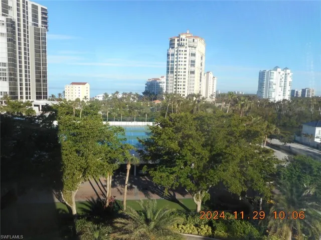 a room with a large window and potted plants