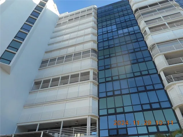 a view of a swimming pool with a yard and palm trees