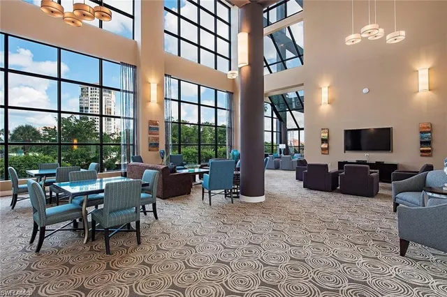 a living room with furniture a large window and a flat screen tv