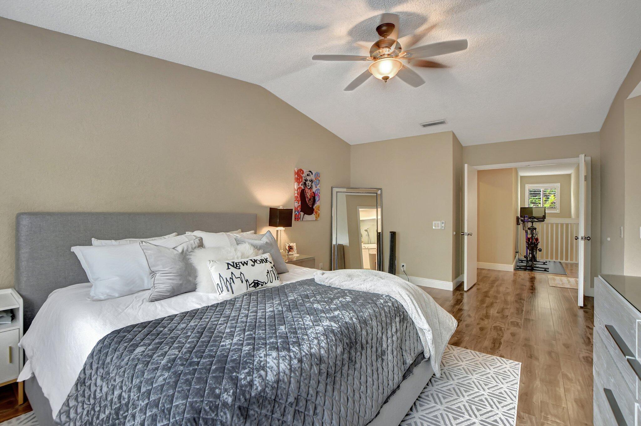 6682 Via Regina Boca Raton, FL 33433 - Photo 21 of 46 a bedroom with a large bed and a chandelier