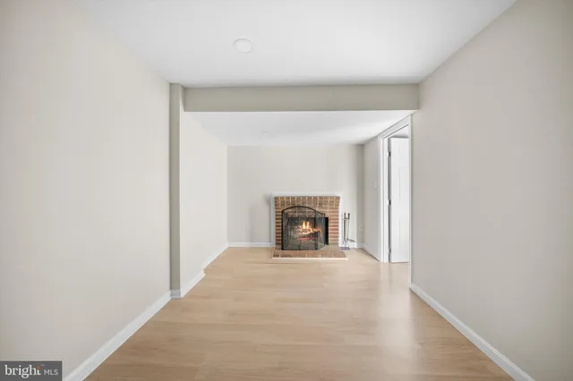 a view of an empty room with a fireplace and a window