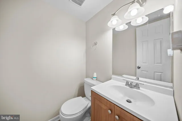 a bathroom with a sink vanity mirror and toilet
