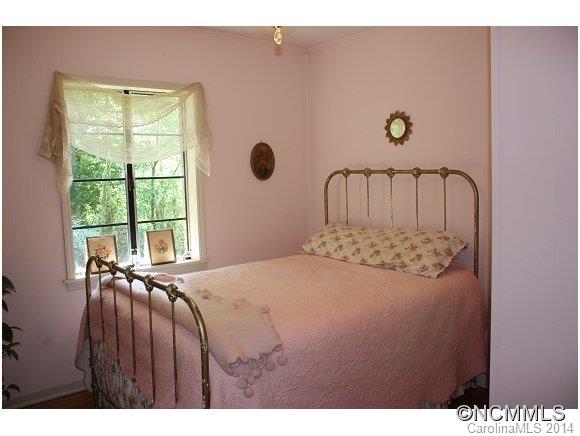 105 Hunting Country Road Tryon, NC 28782 - Photo 9 of 16 a bed sitting in a bedroom next to a window
