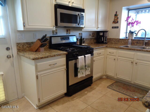 43043 Flag Street Lancaster, CA 93536 - Photo 13 of 29 a kitchen with stainless steel appliances granite countertop a stove a sink and a microwave