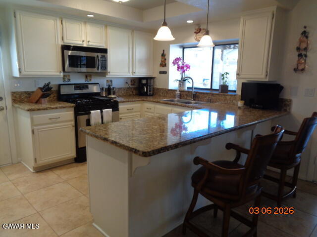43043 Flag Street Lancaster, CA 93536 - Photo 10 of 29 a kitchen with granite countertop a stove a sink and a microwave