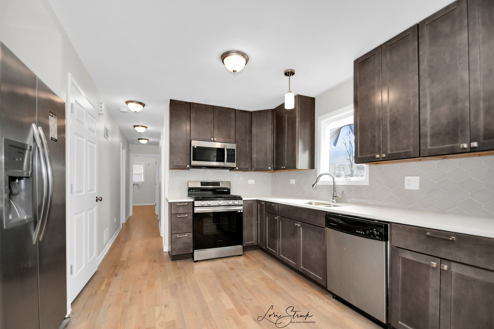 5525 South Emerald Avenue Chicago, IL 60621 - Photo 3 of 29 a kitchen with stainless steel appliances granite countertop a sink a stove a refrigerator cabinets and a wooden floor