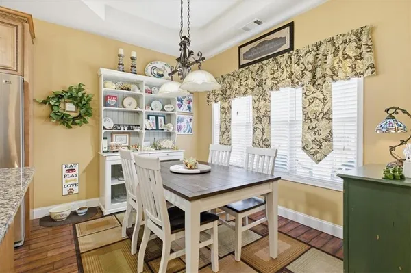 a view of a dining room with furniture a chandelier and wooden floor