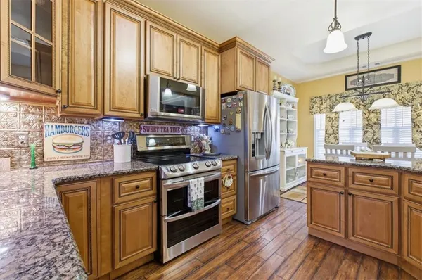 a kitchen with stainless steel appliances granite countertop a stove a sink dishwasher a refrigerator and a microwave