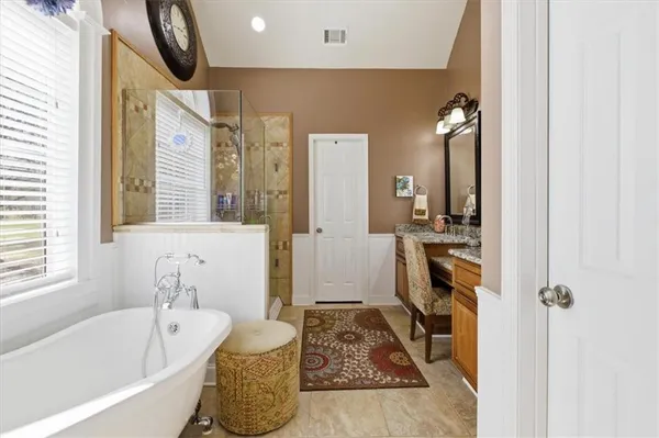 a bathroom with a tub sink and mirror