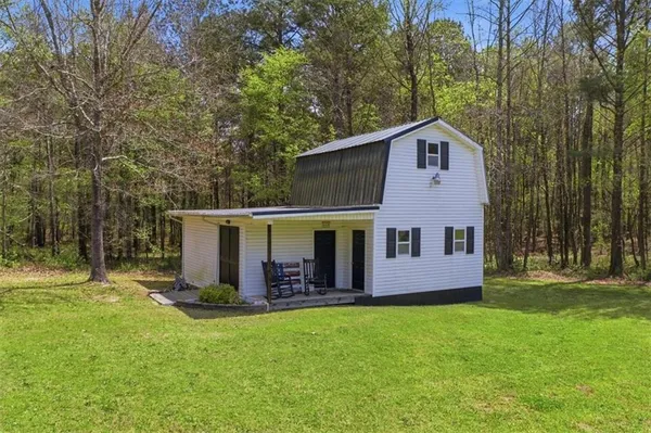 a front view of a house with yard and trees