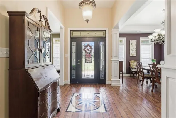 a view of a hallway with wooden floor and furniture
