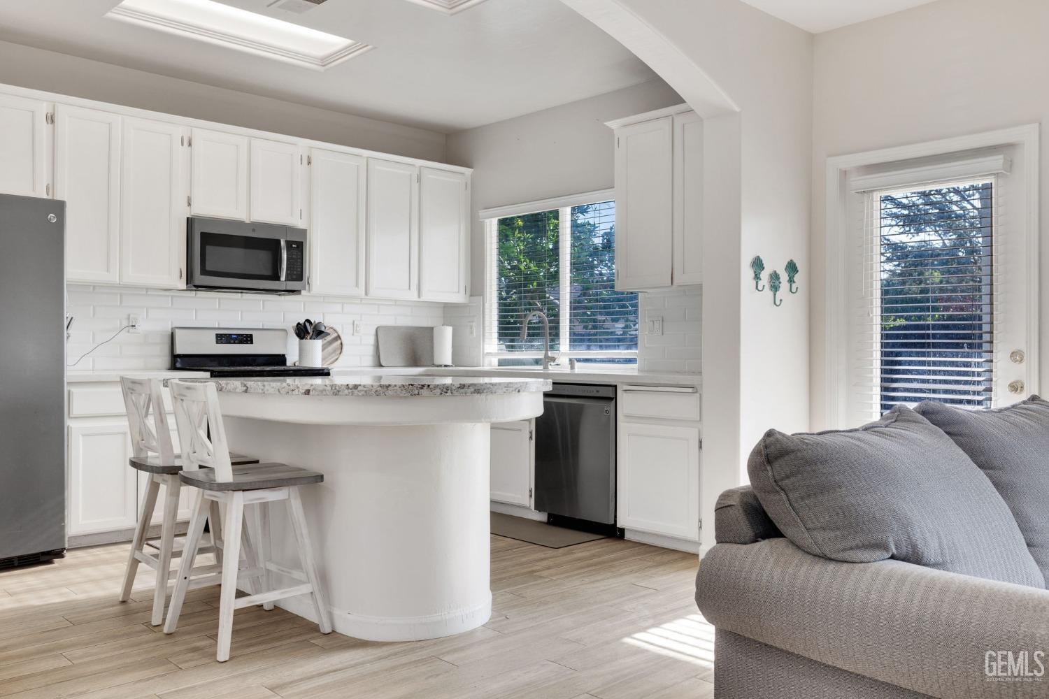 Undisclosed Address Bakersfield, CA 93312 - Photo 16 of 45 a kitchen with stainless steel appliances granite countertop a stove a sink a microwave a refrigerator and white cabinets