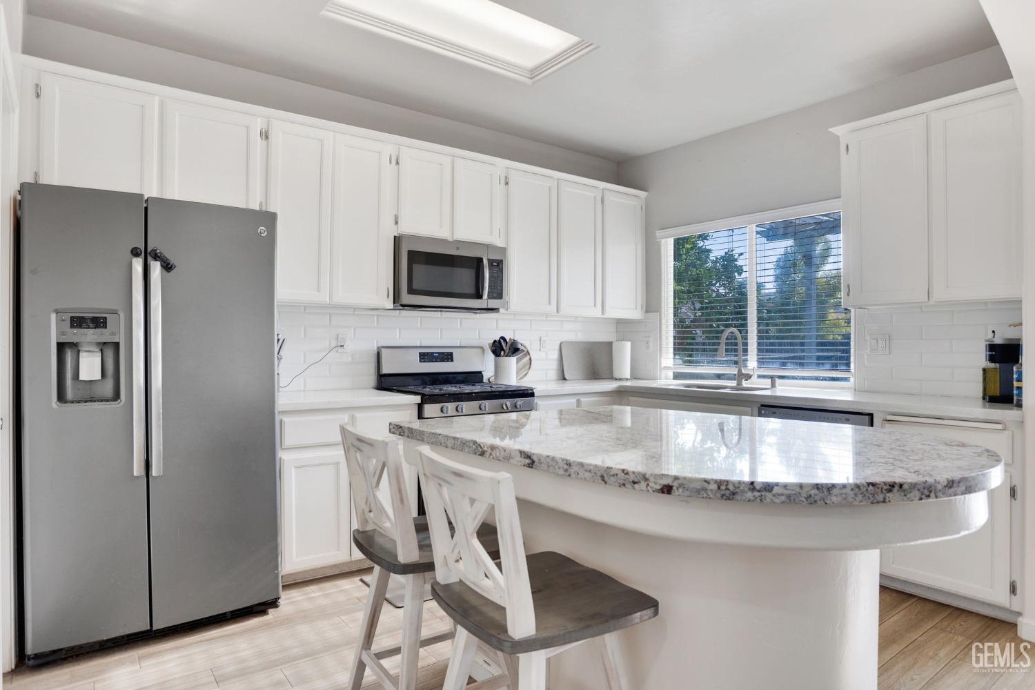 Undisclosed Address Bakersfield, CA 93312 - Photo 17 of 45 a kitchen with stainless steel appliances granite countertop a sink a stove a refrigerator cabinets and a window
