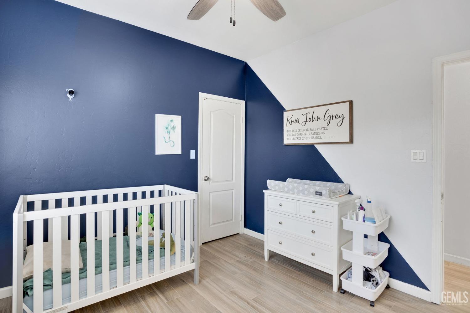 Undisclosed Address Bakersfield, CA 93312 - Photo 33 of 45 a view of a bedroom with baby crib and wooden floor