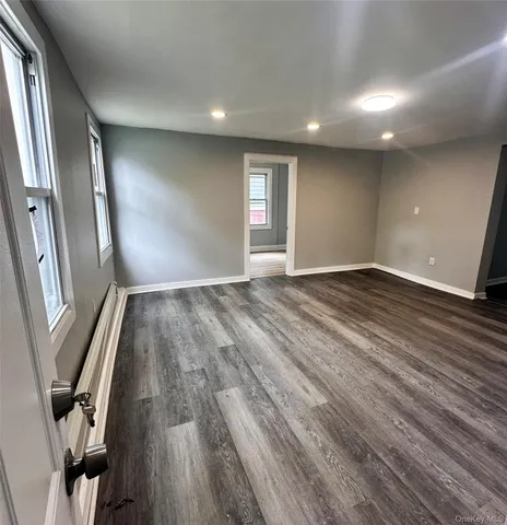 a view of an empty room with wooden floor