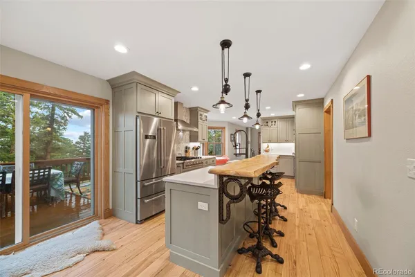 a kitchen with stainless steel appliances granite countertop a refrigerator a sink and a stove