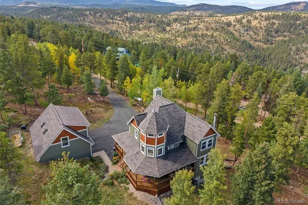 a aerial view of a house with swimming pool and large trees