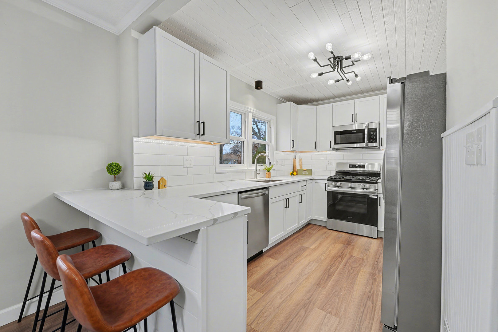 3634 178th Street Lansing, IL 60438 - Photo 9 of 28 a kitchen with stainless steel appliances a white refrigerator a stove a sink dishwasher and white cabinets with wooden floor