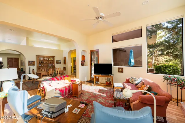 a living room with furniture a flat screen tv and a floor to ceiling window