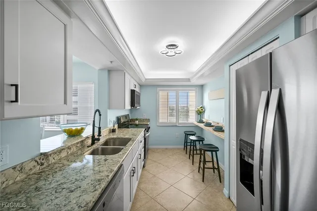 a kitchen with granite countertop a sink a stove and refrigerator