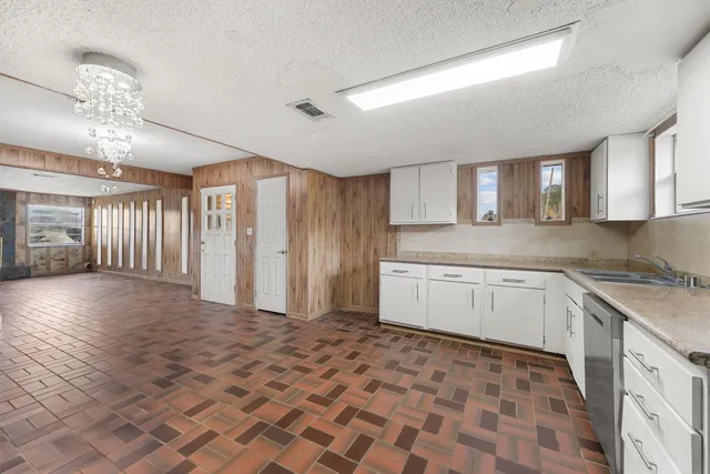 a kitchen with granite countertop a stove a sink and a refrigerator